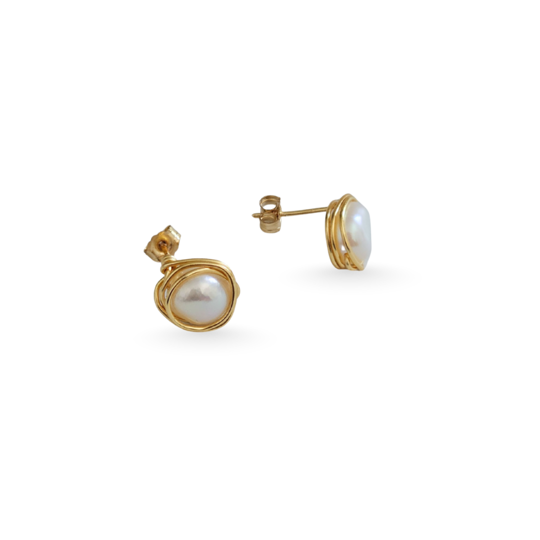 Gold earrings with pearl stones on a white background