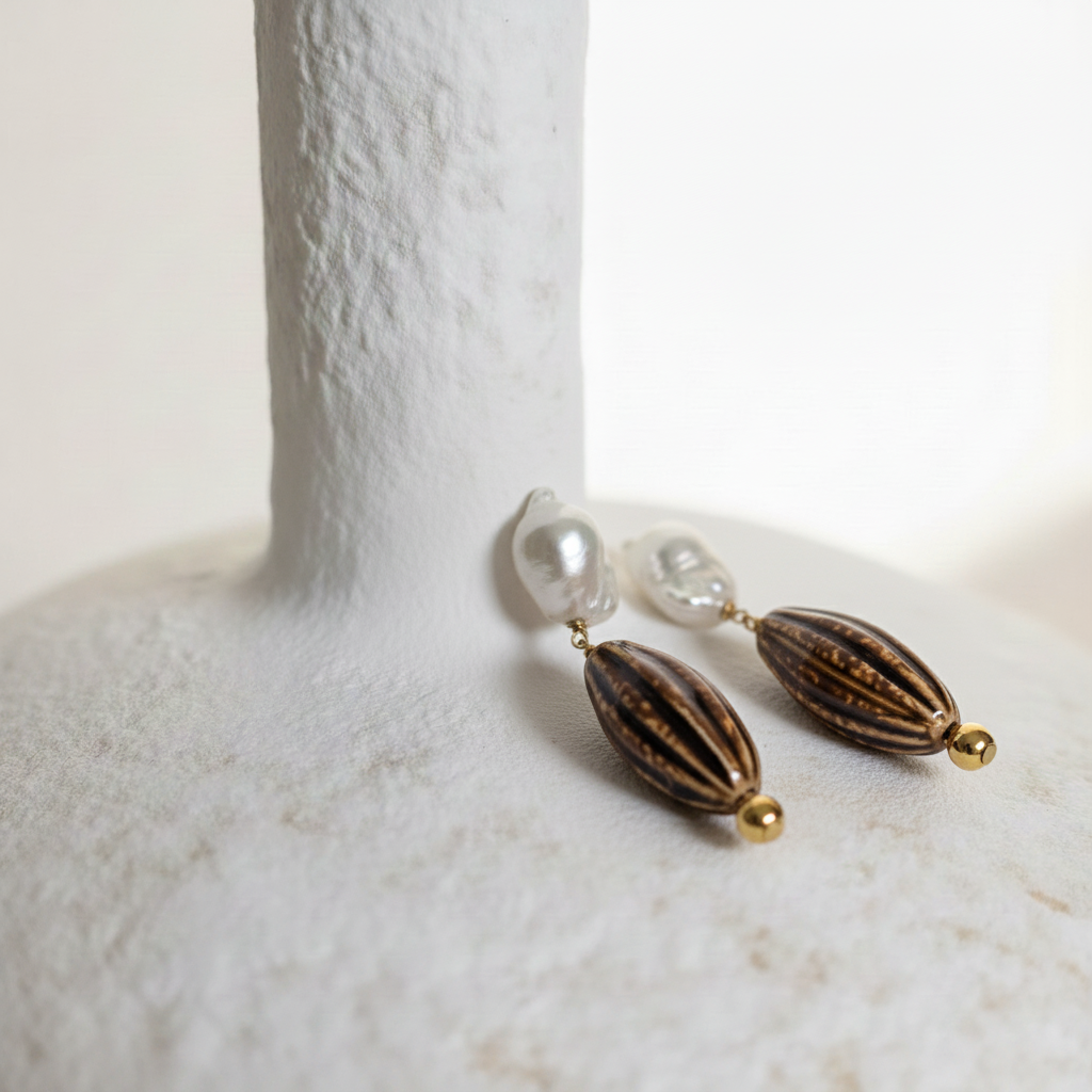 Pair of earrings with brown and gold elements on a white surface