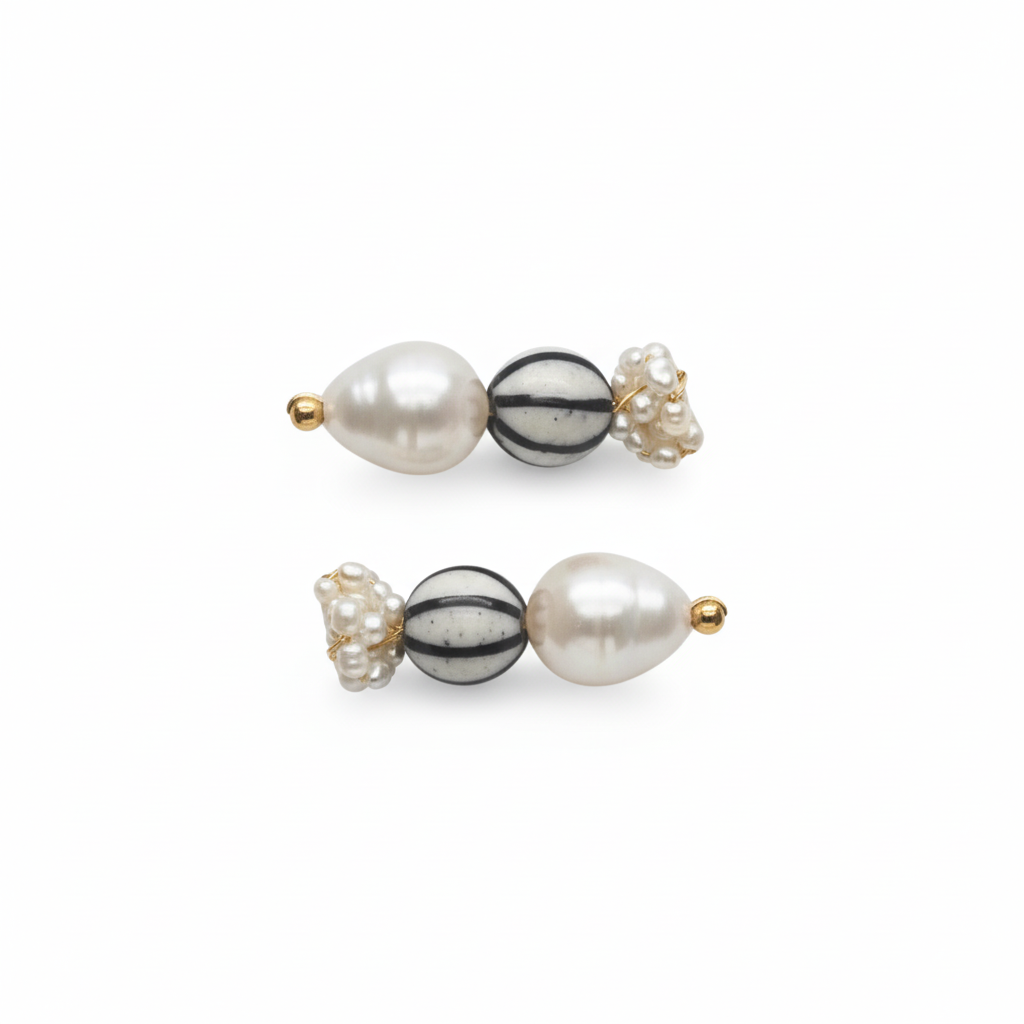 Pair of pearl and black and white striped earrings on a white background