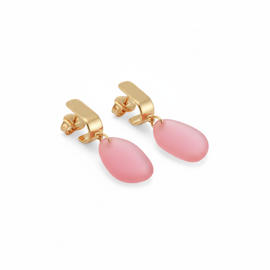 Gold earrings with pink teardrop-shaped stones on a white background