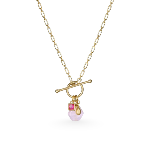 Gold necklace with a toggle clasp and pink gemstone pendant on a white background