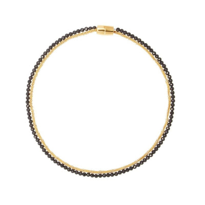 Necklace with black beads and gold clasp on a white background