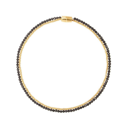 Necklace with black beads and gold clasp on a white background