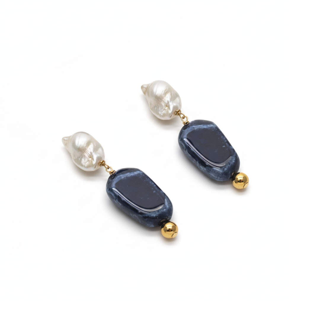 Pair of earrings with blue and gold beads on a white background
