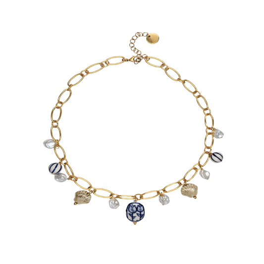 Gold chain bracelet with various beads on a white background