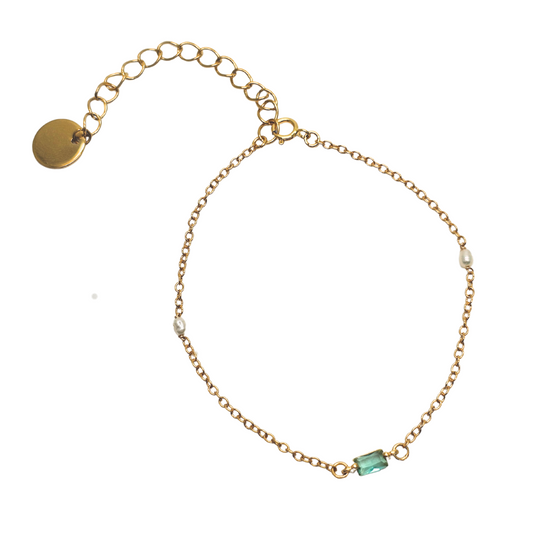 Gold bracelet with a green gemstone on a white background