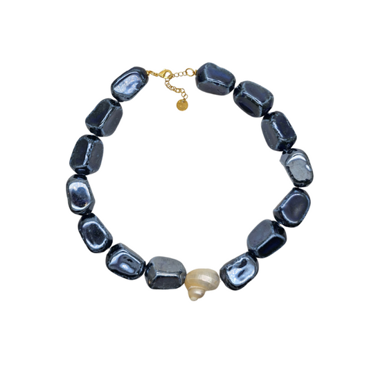 Necklace with dark blue beads and a gold clasp on a white background